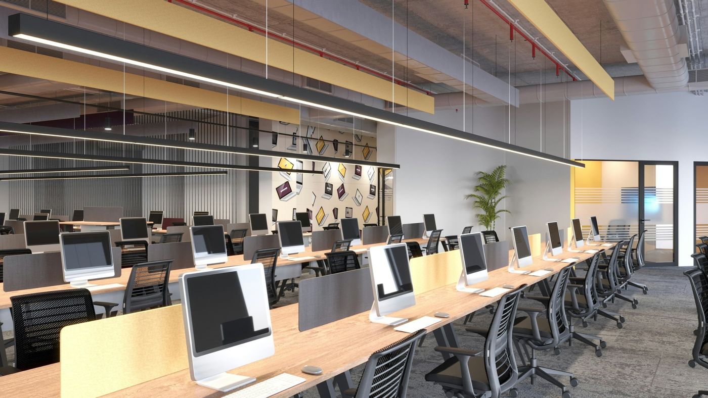 An empty office with rows of computers ready for the day